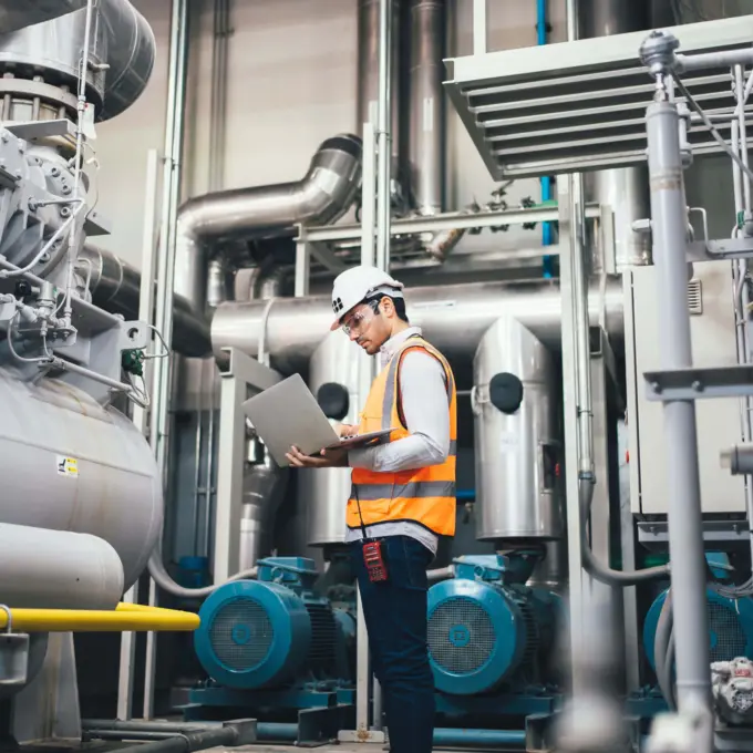 Employee on a laptop in an industrial facility